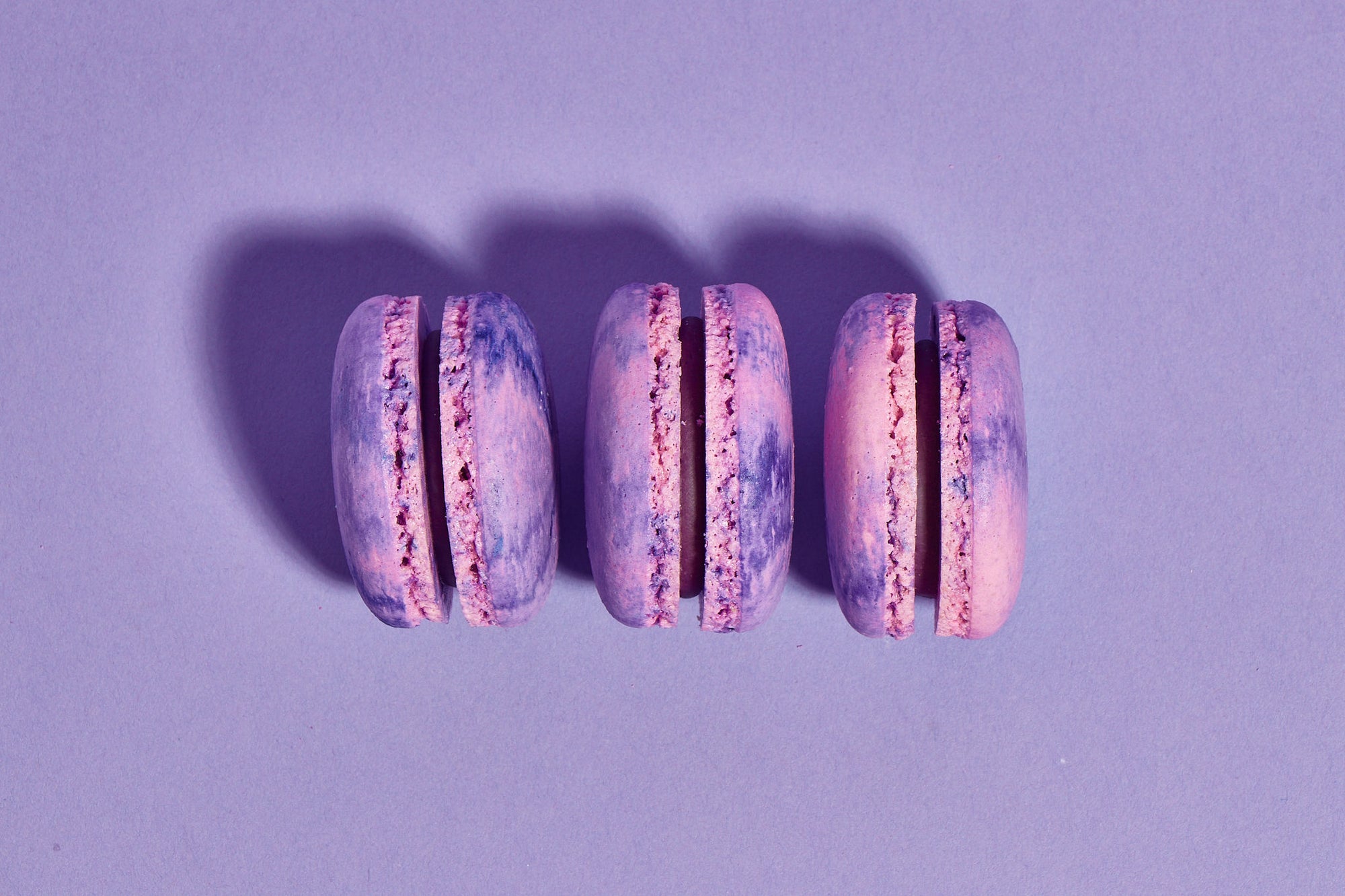 Three purple macarons lined up in a row