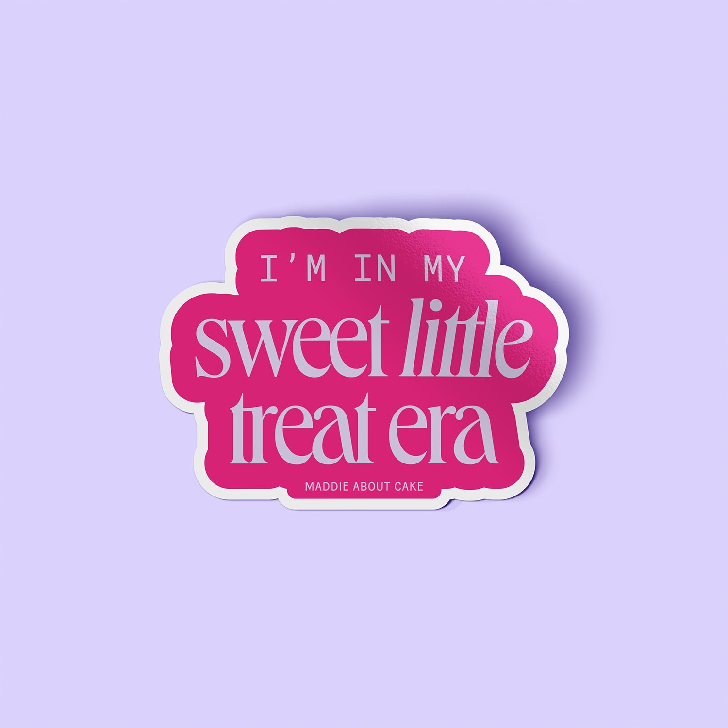 Decorative sticker that says "I'm in my sweet little treat era" in lilac text on a hot pink background. The sticker is laying on a lilac background. 