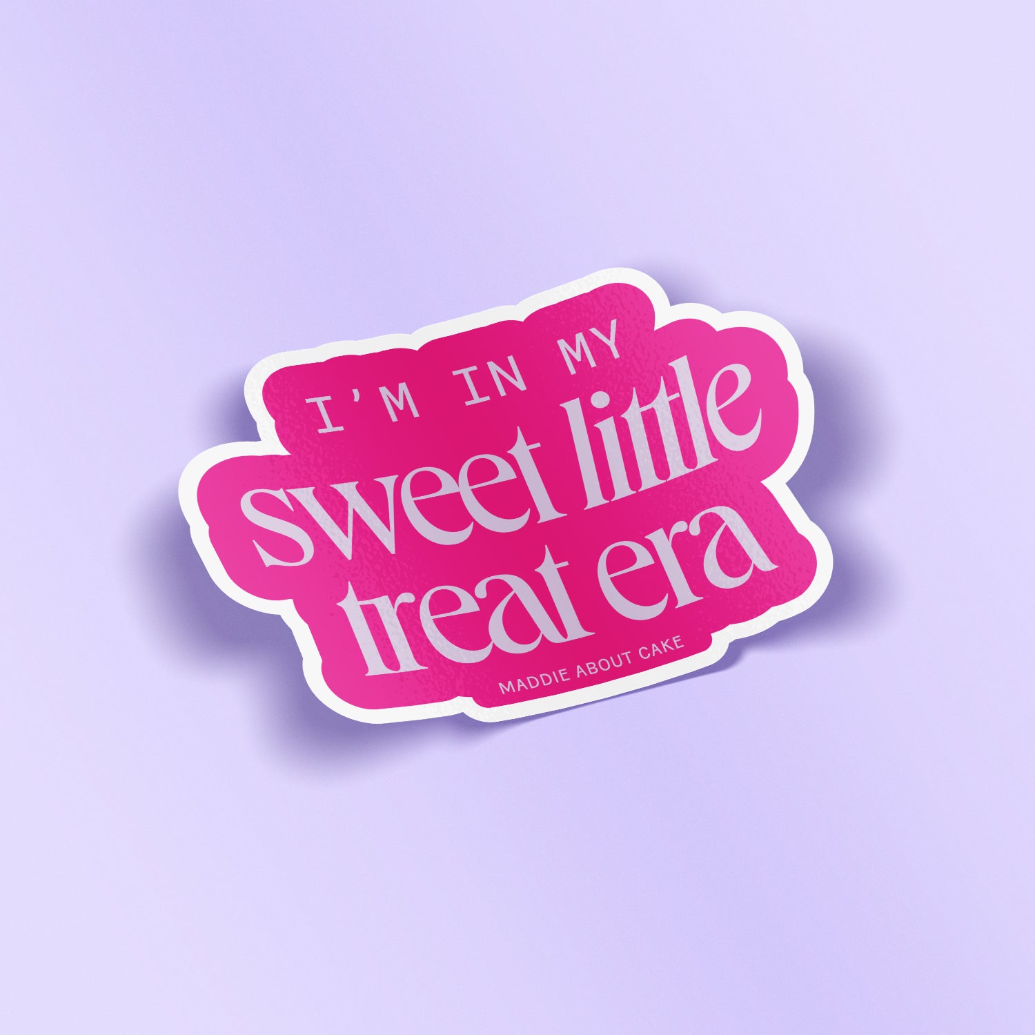 Decorative sticker that says "I'm in my sweet little treat era" in lilac text on a hot pink background. The sticker is laying on a lilac background.
