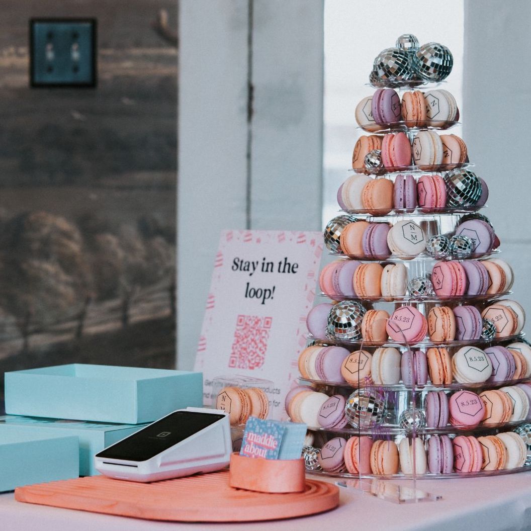 Ten-tier macaron tower that holds a variety of custom macarons in pink, orange, purple in white. The macarons are also adorned with a wedding monogram that is custom printed by Maddie About Cake, a macaron microbakery in Louisville, Kentucky. Photo by Kate Starkel.